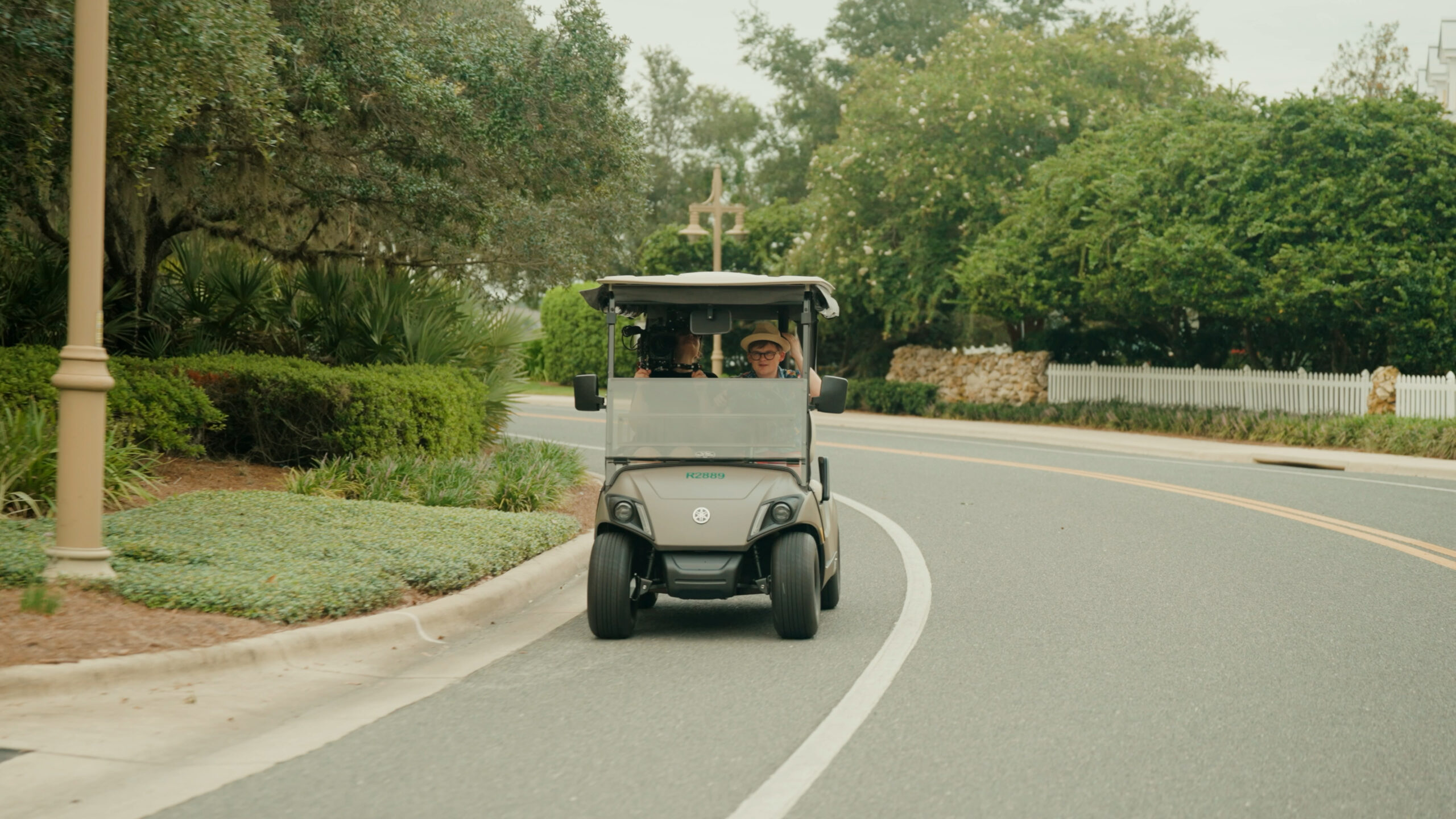 Tom Nicholas and Valentina Vee ride a golf cart in Florida.